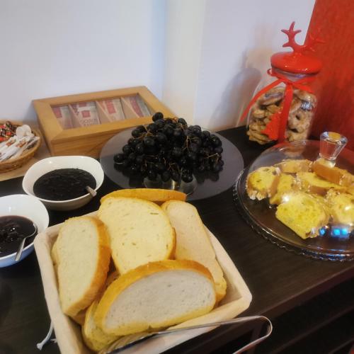 Una mesa con pan y huevos y un plato de fruta. en Pensiunea Rasnov, en Râșnov