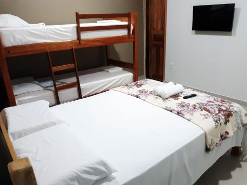 Un dormitorio con dos literas y un televisor. en Hotel Brio, en Salinópolis