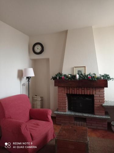 a living room with a red couch and a fireplace at Mulino di Limido in Zerbolò