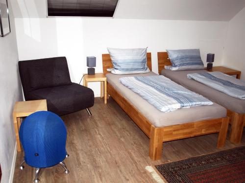 クサンテンにあるFerienwohnung HeeserBerg Xantenのベッドルーム1室(ベッド2台、椅子付)