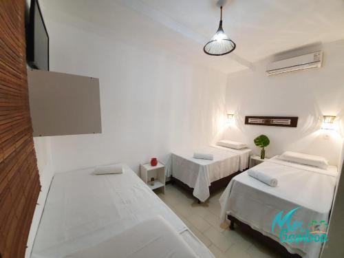 a hospital room with two beds and a tv at Pousada Mar da Gamboa in Cayru