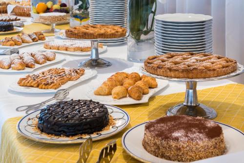 a table with many different types of cakes and pastries at Sant Alphio Garden Hotel & SPA in Giardini Naxos