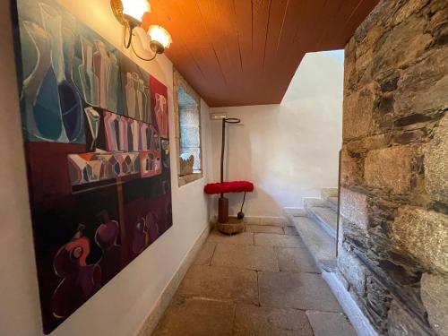 un pasillo con pinturas en la pared y un banco rojo en Rectoral de Cines en Oza dos Ríos