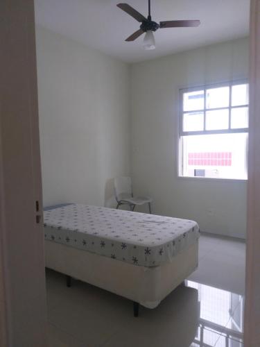 a bedroom with a bed and a ceiling fan at Apartamento para temporada Ambiente familiar in Santos