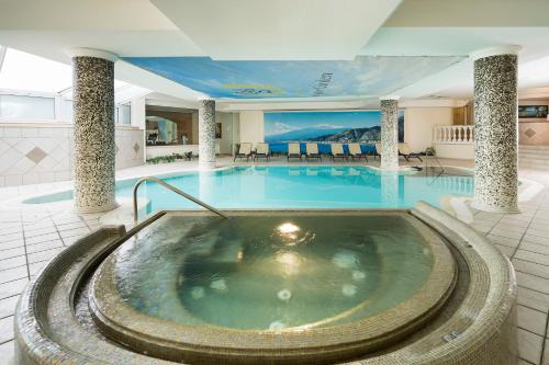 a large pool in a hotel with a hot tub at Sant Alphio Garden Hotel & SPA in Giardini Naxos