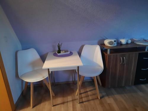 two white chairs and a table in a room at Ferienwohnung Garz in Garz-Rügen