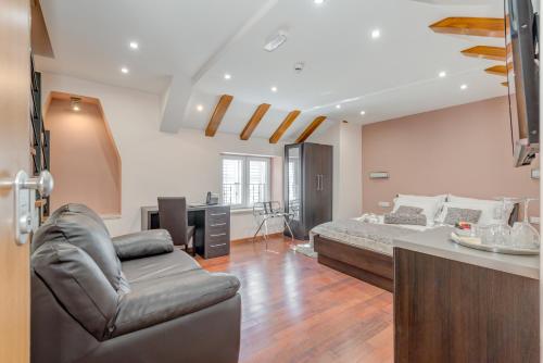 a bedroom with a bed and a couch in a room at Palace Suites Heritage Hotel - Adults Only in Split