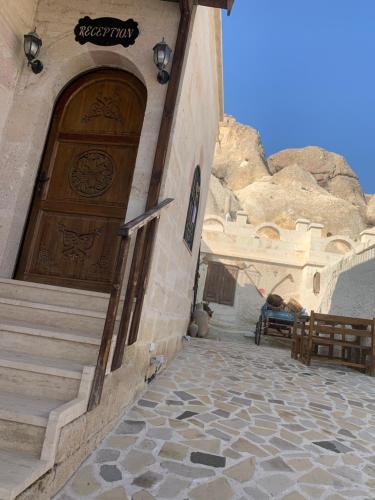a building with a wooden door with a stone walkway at Tatlı Kaya Otel in Urgup