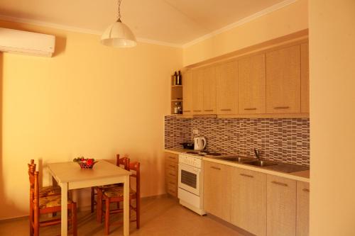 a kitchen with a table and a sink and a counter at Tsoutsis Apartments in Marantochori