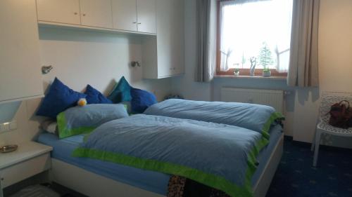 1 dormitorio con 2 camas con sábanas azules y verdes en FeWo Steibis Lodge, Oberstaufen/Steibis, en Oberstaufen