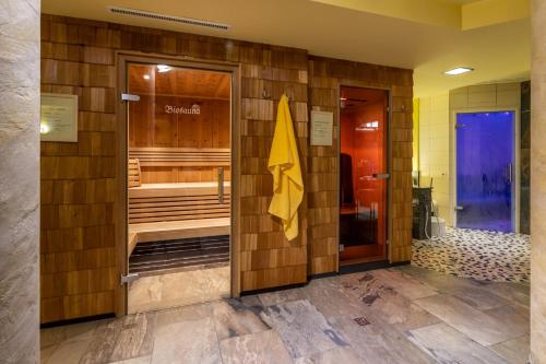 a bathroom with a wooden wall with a sauna at Gasthof Bären in Holzgau