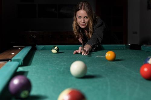 a woman sitting at a pool table with balls at Gasthof Bären in Holzgau