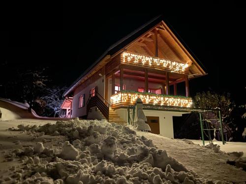 a building with christmas lights on it in the snow at Holiday home Tihovo in Delnice