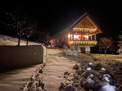 a house at night with a pile of snow in front at Holiday home Tihovo in Delnice
