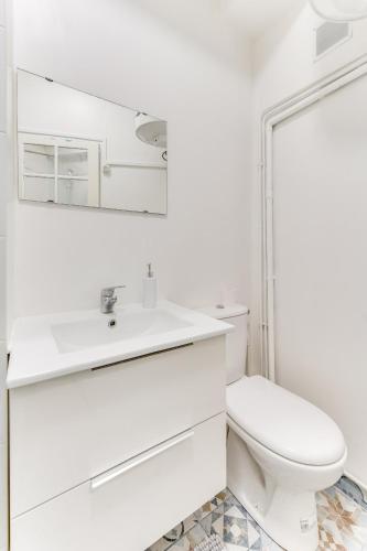 une salle de bain blanche avec des toilettes et un lavabo dans l'établissement L'emplacement Idéal - Tour Eiffel 10min - NETFLIX -, à Paris