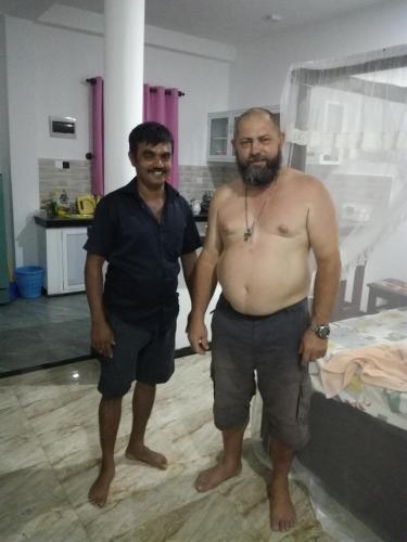 two men standing next to each other in a room at Indika's Apartment in Hikkaduwa