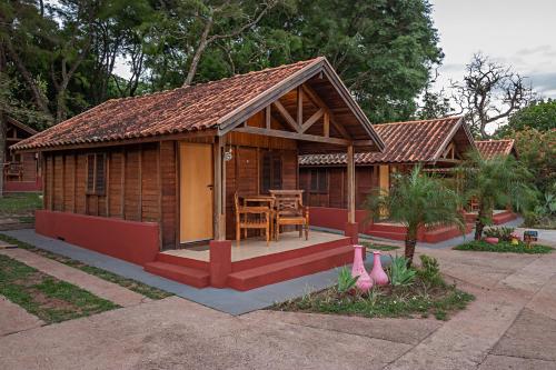 a small wooden house with a table and chairs at Gaia Hospedagem Holística in Brotas