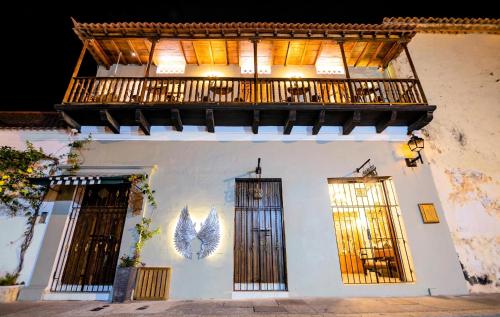 a white building with a balcony and two doors at Scalea Di Mare Hotel in Cartagena de Indias