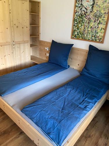 un letto con cuscini blu in una stanza di Brentwaldhof Appartements a Cornedo all'Isarco