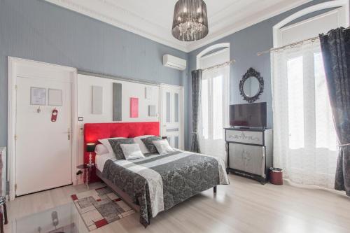 a bedroom with a bed and a red headboard at Hôtel de Charme Le Provence in Salon-de-Provence