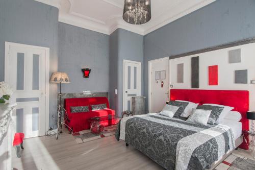a bedroom with a red bed and a red chair at Hôtel de Charme Le Provence in Salon-de-Provence