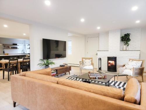a living room with a couch and a fireplace at Hideaway Lodge - Glen Lake, Lake George in Lake George