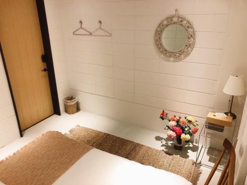 Zimmer mit einem Bett und einer Blumenvase in der Unterkunft LESTEL - Vacation STAY 94889 in Naha