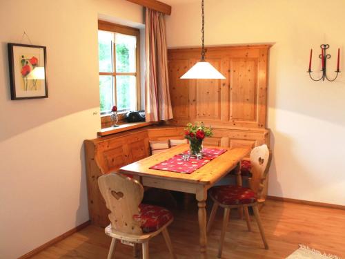 a dining room with a wooden table and chairs at Schmuckhäusl in Reit im Winkl
