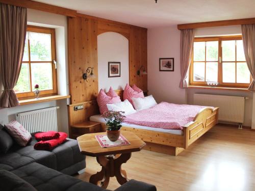 Un dormitorio con una cama, un sofá y una mesa. en Schmuckhäusl, en Reit im Winkl