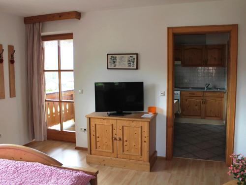 sala de estar con TV en un armario de madera en Schmuckhäusl, en Reit im Winkl