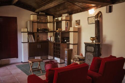 a living room with red chairs and a fireplace at Casa de Marlães in Lousada