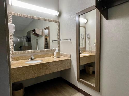 baño con 2 lavabos y espejo grande en Fairview Inn & Suites Mobile, en Mobile