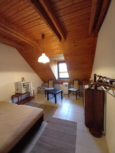a bedroom with a bed and a tv in a room at Edelmann Panzió in Balatonakali