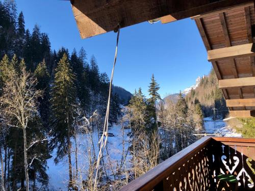 a balcony with a view of a snow covered forest at Chalet en Haute Savoie Location ski 2 appartements pour 6 ou 8 personnes Saint Gervais Les Bains in Saint-Gervais-les-Bains