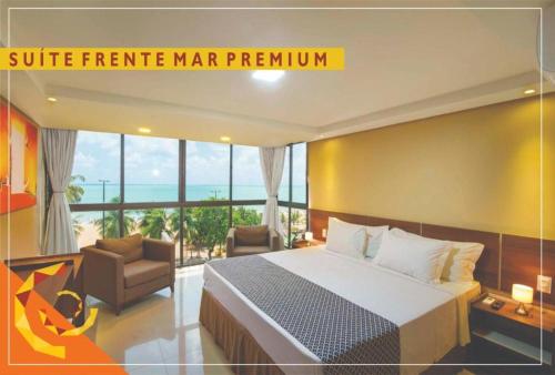 a hotel room with a bed and a chair at Netuanah Praia Hotel in João Pessoa