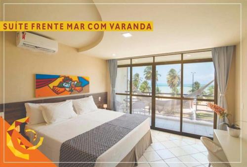 a bedroom with a bed with a view of the ocean at Netuanah Praia Hotel in João Pessoa