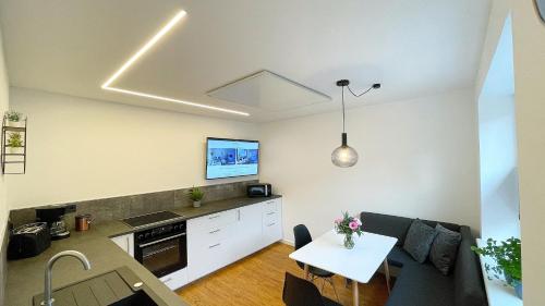 a kitchen and living room with a table and a dining room at Uraha Apartments Fürth in Fürth