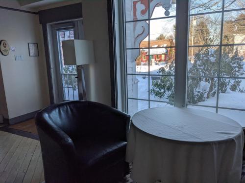 a room with a table and a chair and a window at Gingerbread House Inn - We Are Open - Winter, Spring, Summer and Fall in Wolfville