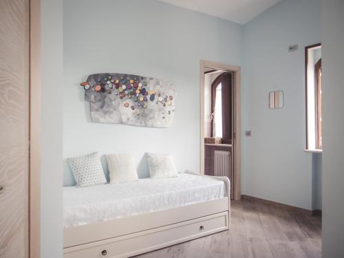 una camera bianca con un letto e un dipinto sul muro di Agriturismo Ragozzino / De Marco a Pontelatone