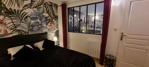 een slaapkamer met een bed met zwart-witte kussens bij LE PATIO / les suites romantiques du grenier à sel in Honfleur