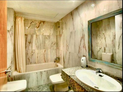 a bathroom with a sink and a tub and a toilet at SeaHomes Vacations, BEACH&POOL, in Fenals Beach in Lloret de Mar