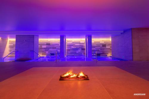 a fire pit in a room with purple lights at San Severino Park Hotel & SPA, BW Signature Collection in Mercato San Severino