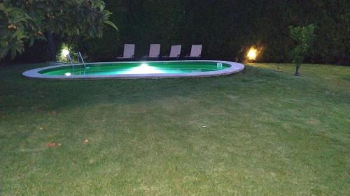 a swimming pool at night with two chairs around it at Casa de Marlães in Lousada