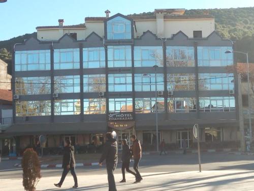 a group of people walking in front of a building at Hôtel chahrazad in Imouzzer Kandar