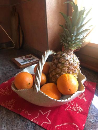 a bowl of fruit with a pineapple and oranges at Chalet Anna Chiara in Arola