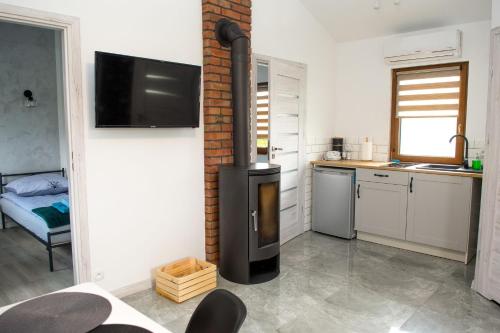 a kitchen with a stove in the corner of a room at Natalia Rest domki & camp in Tałty