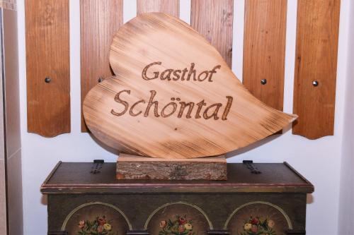 a wooden sign for a school on top of a box at Gasthof Schöntal in Oberau