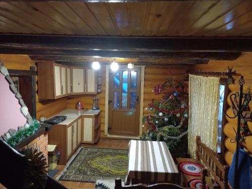a kitchen with a christmas tree in a cabin at Затишний будиночок in Bukovets