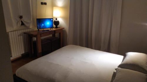 a bedroom with a bed and a television on a table at Hotel Belmonte inn in Belmonte Piceno