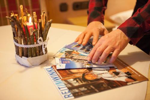 a table with a person holding a stack of pamphlets at Gästehaus Angerer in Reit im Winkl